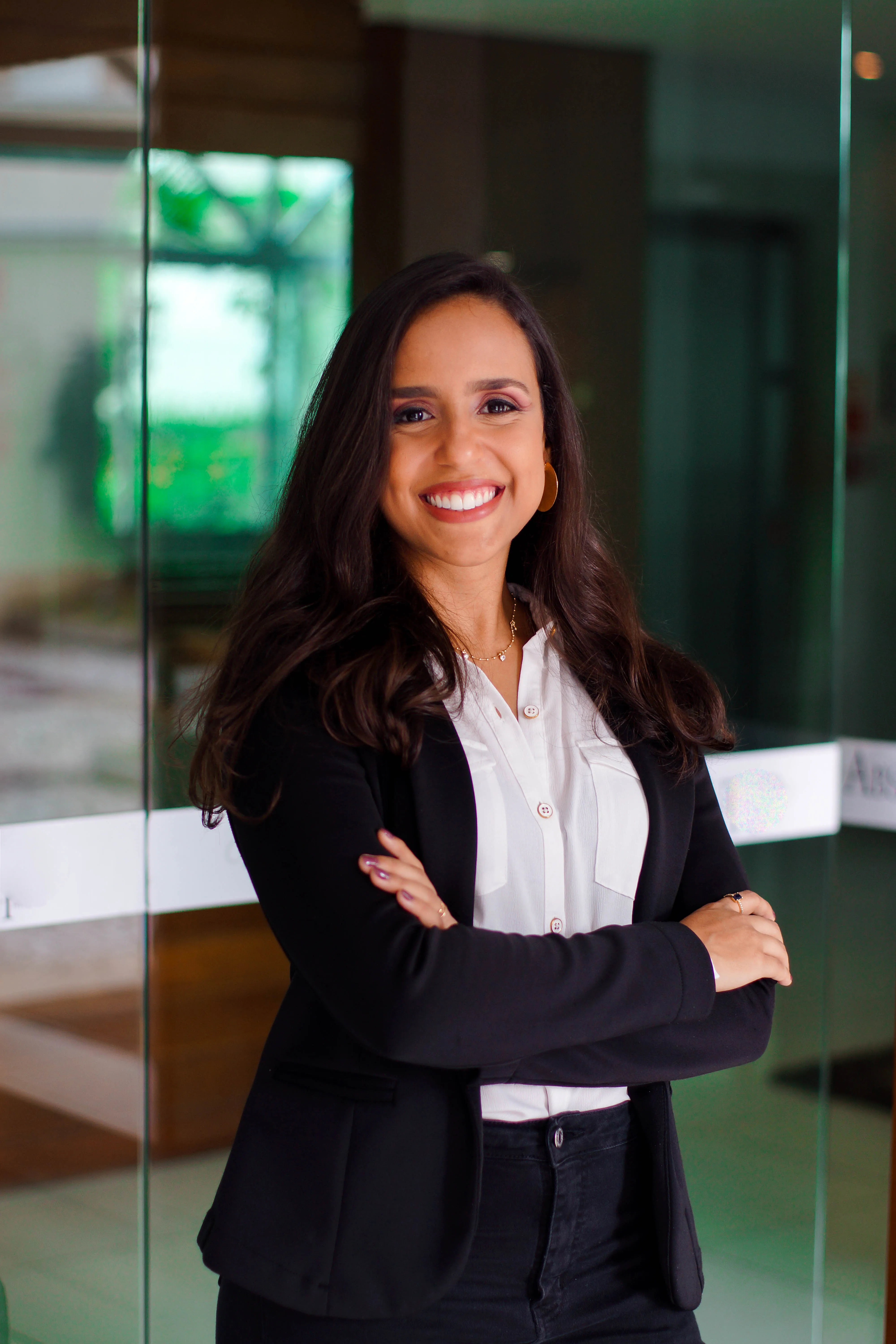 Luana Cerqueira, psicóloga, de braços cruzados em retrato profissional